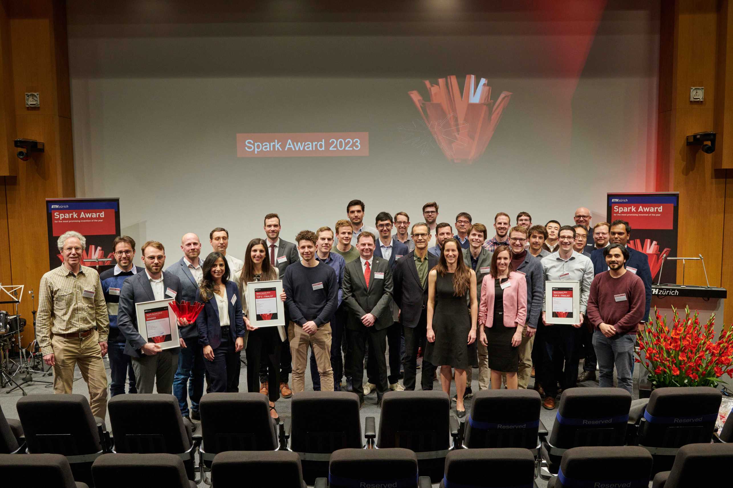 People stand on the stage of the Audi Max. In the background, Spark Award 2023 is written on the wall.